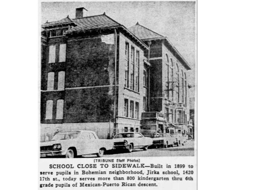 A black-and-white image of a building with cars parked in front of it. Text reads School close to sidewalk–Built in 1899 to serve pupils in Bohemian neighborhood, Jirka school, 1420 17th st., today serves more than 800 kindergarten thru 6th grade pupils of Mexican-Puerto Rican descent. 