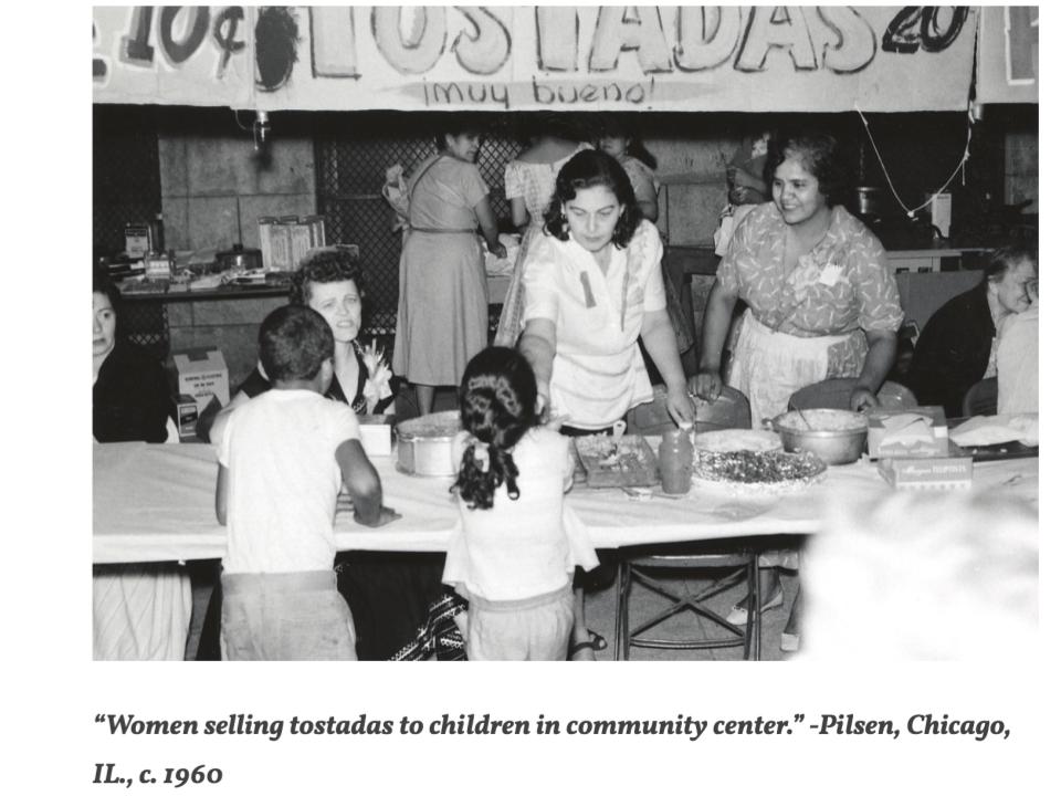 A black-and-white image of several women serving food to 2 children. Text reads “Women selling tostadas to children in community center.” -Pilsen, Chicago, IL., c. 1960